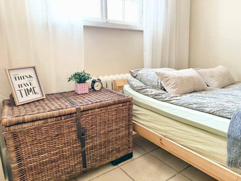 a bedroom with a bed and a table with a basket at The City Centre Apartment Turku in Turku