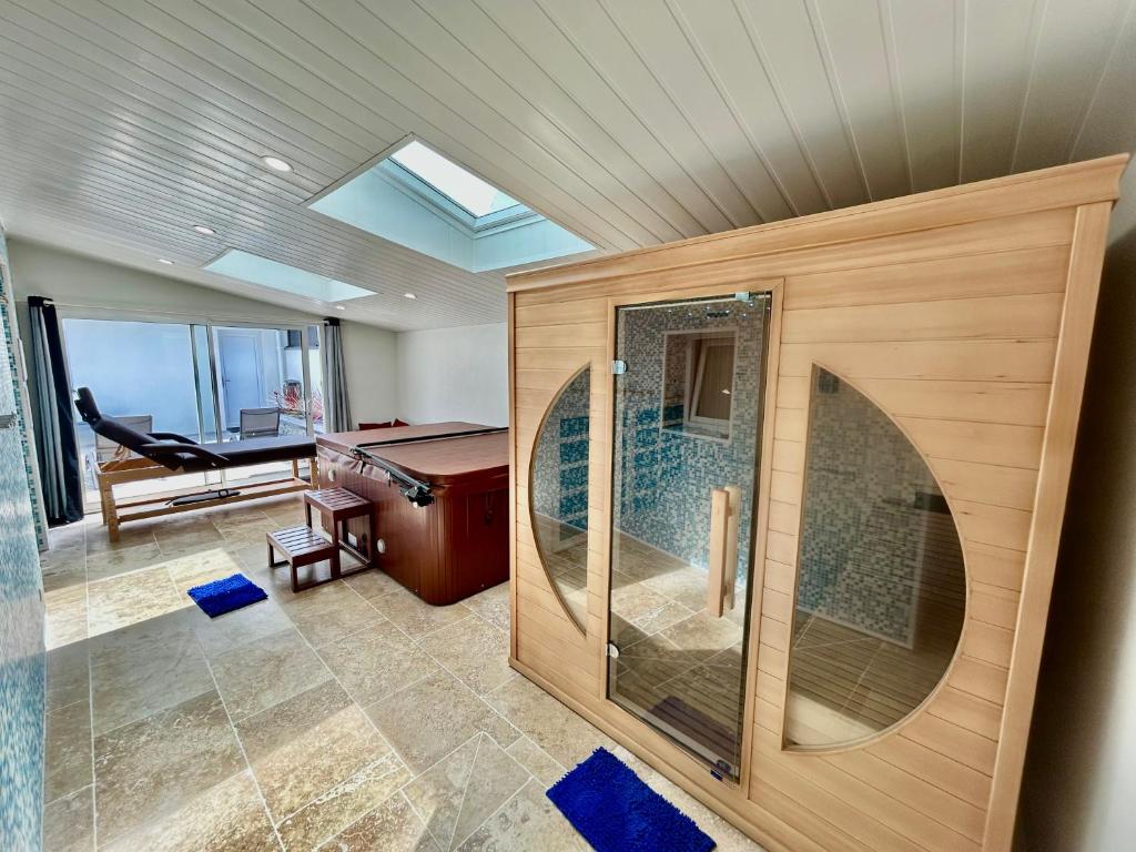 une salle de bain avec une douche avec une porte vitrée dans l'établissement Logement thérapie bien-être, à Pont-lʼAbbé