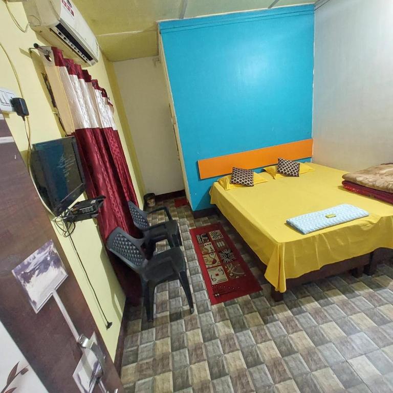 a room with a bed and a table and a chair at Shilong DC Guest House with View and Good Facilities in Guwahati