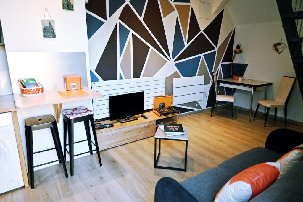 un salon avec un canapé et une télévision dans l'établissement Still vintage 67 appartement proche de Strasbourg, à Still