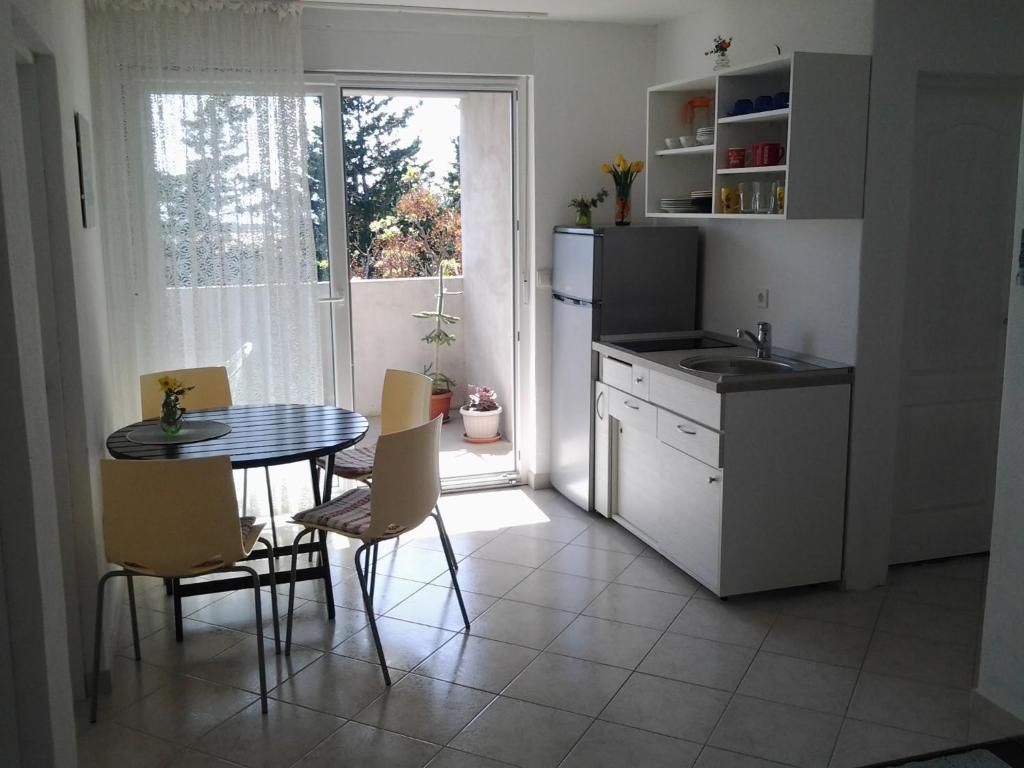a kitchen with a table and a sink and a table and chairs at Apartments MiaMaja in Novalja