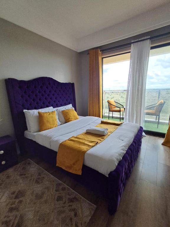 une chambre avec un grand lit avec une grande fenêtre dans l'établissement Favorite staycation, à Nairobi
