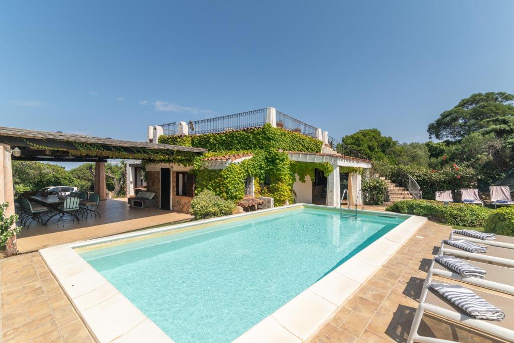 a swimming pool in front of a house at Villa Ginepro con Piscina Privata in San Teodoro