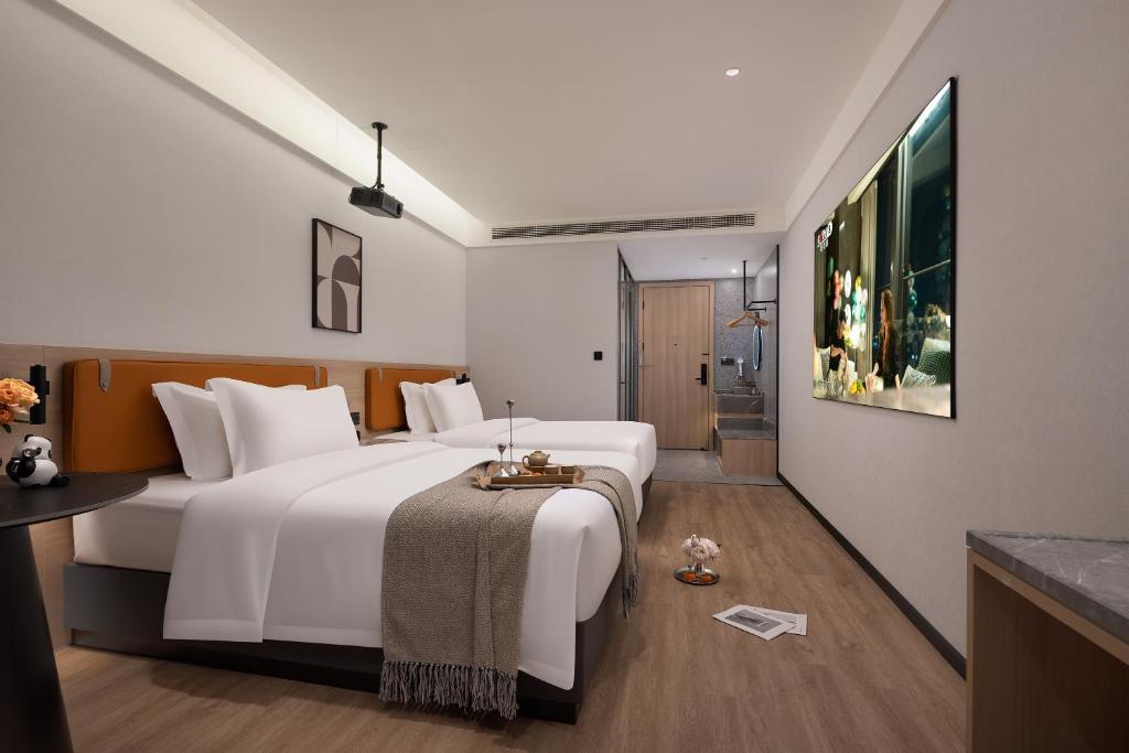 重庆Wuxuan Hotel Zoo Branch的一间带白色大床的卧室和一间浴室