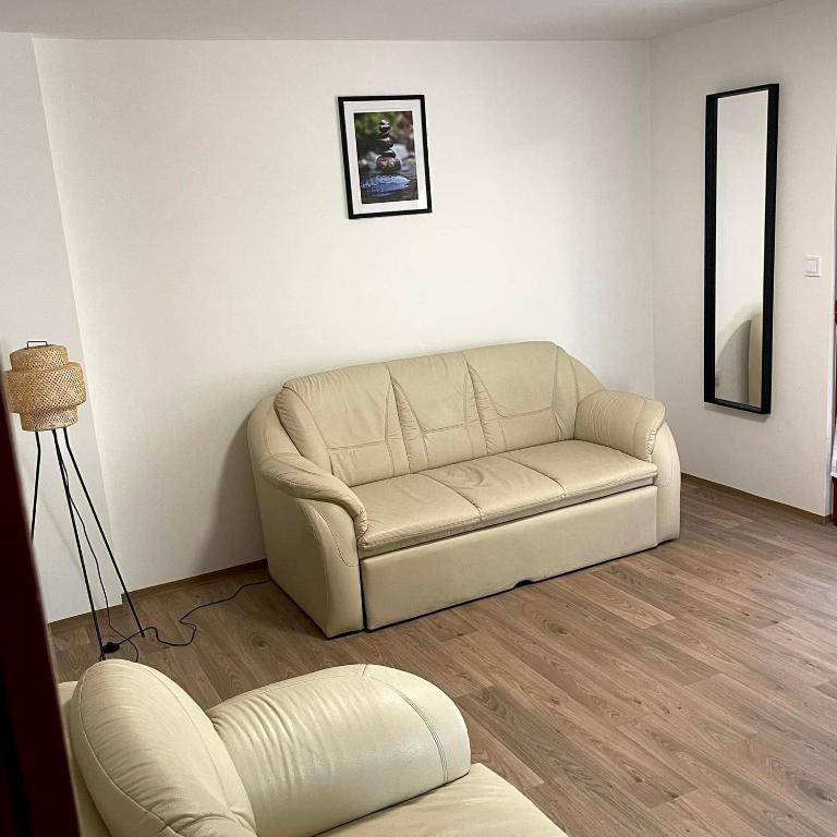 a living room with a couch and a mirror at Apartmanház - Delta Kemping in Balatonederics
