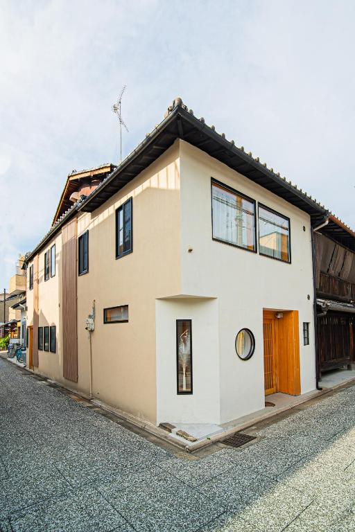 a white house with a black roof on a street at 夏様五条丹波口 Modern Kyoto Townhouse, Whole House in Kyoto