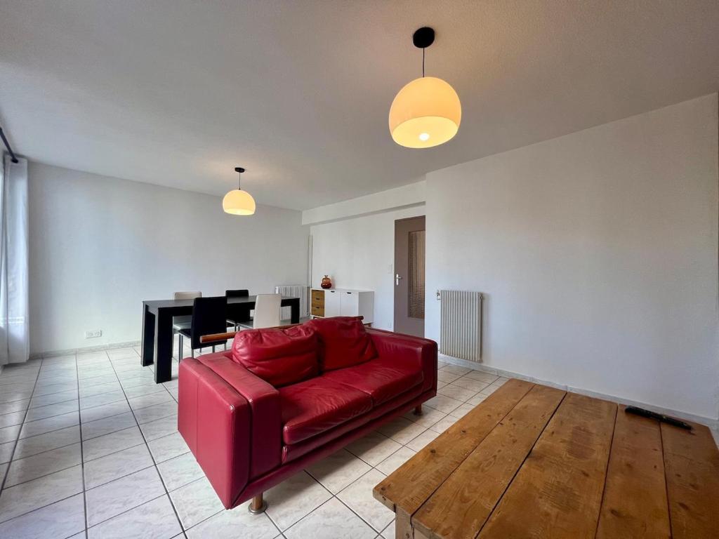 un salon avec un canapé rouge et une table dans l'établissement Beau T3 avec balcon à Perpignan, à Perpignan