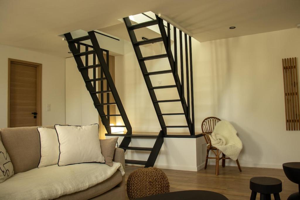 un salon avec un canapé et un escalier en colimaçon dans l'établissement Suite Ma Bohème, 4pers Chic et atypique, à Charleville-Mézières