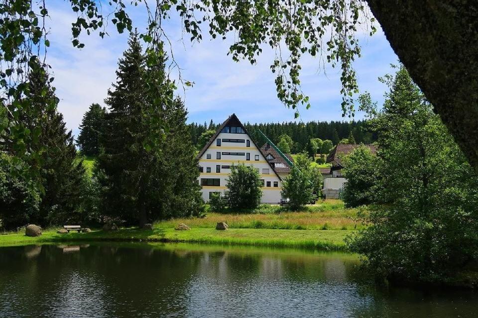 a large white building next to a lake at Ferienwohnung in Schönwald