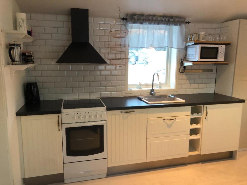a kitchen with a sink and a stove at Cozy cottage on horse farm in Bollnäs in Bollnäs