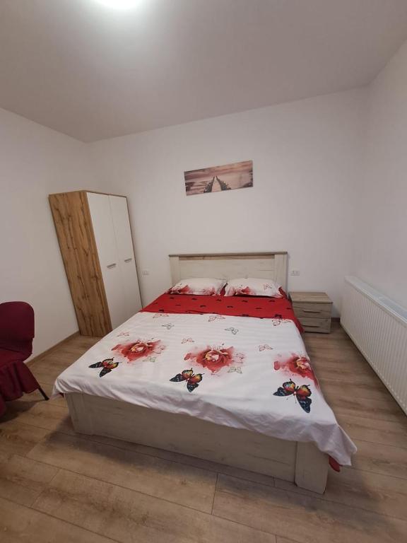 a bedroom with a bed with a red and white comforter at Sea Wave House in Constanţa