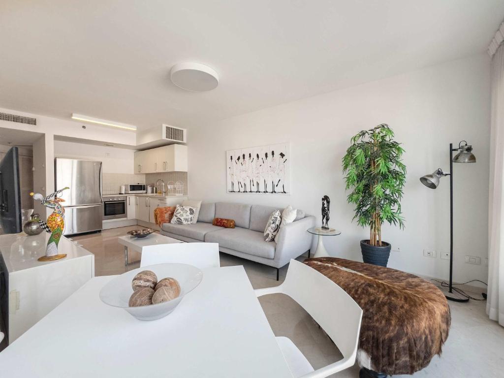 a living room with a couch and a table at Breeze Suite at The Island in Herzliya B