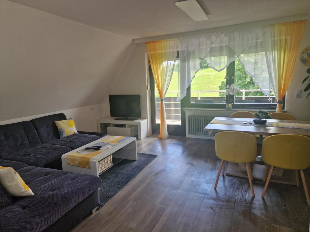 a living room with a couch and a table at Ferienwohnung in Schonwald im Schwarzwald