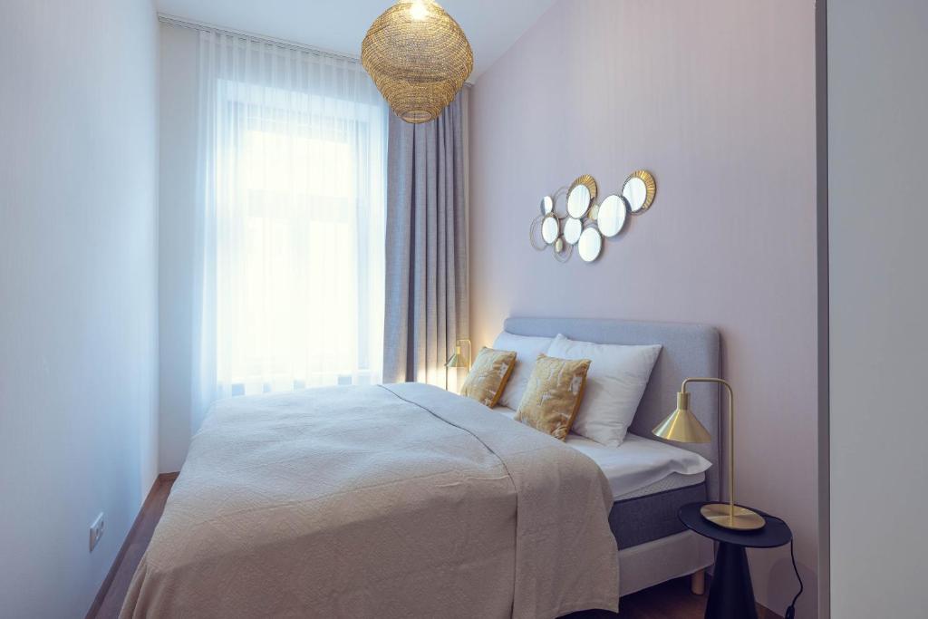 a white bedroom with a bed and a window at LeonArt Living 21 in Graz