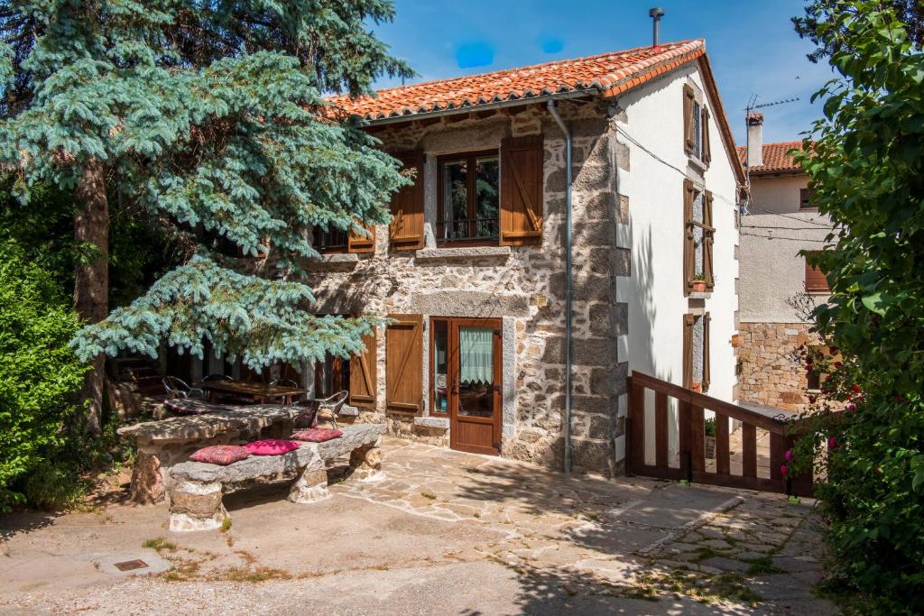 una casa in pietra con tetto rosso di La Esperilla De Gredos a Navarredonda de Gredos