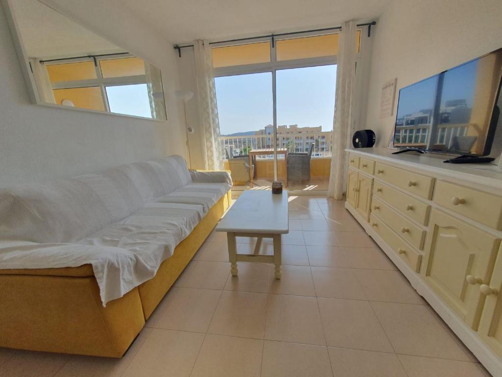 un soggiorno con un divano e un tavolo di Alquilaencanarias-Medano Lagos de Miramar I a El Médano