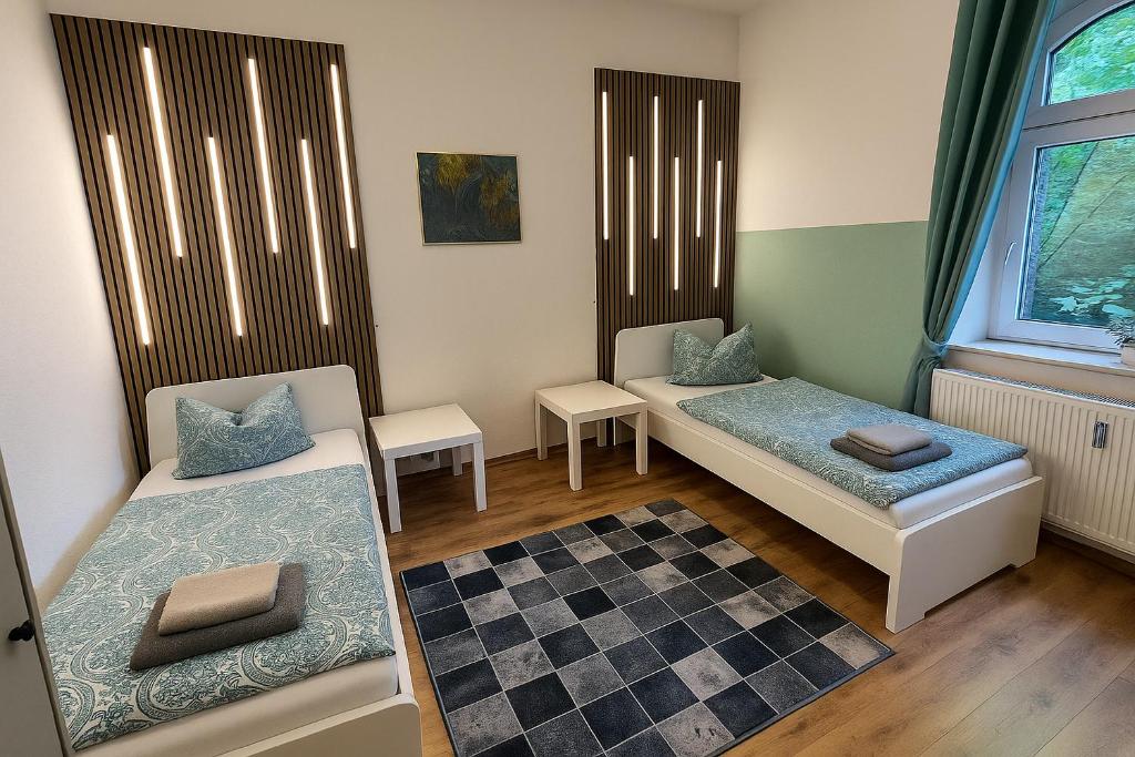 ein kleines Zimmer mit zwei Betten und einem Fenster in der Unterkunft Comfort & Relax mit Sky & PlayStation - Haus Burgstadt in Altena