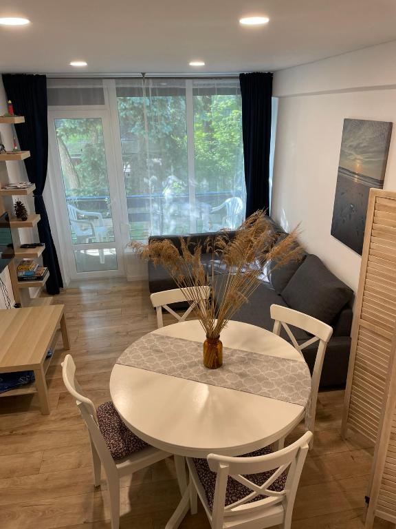 a living room with a table and a couch at Preilos39 in Preila