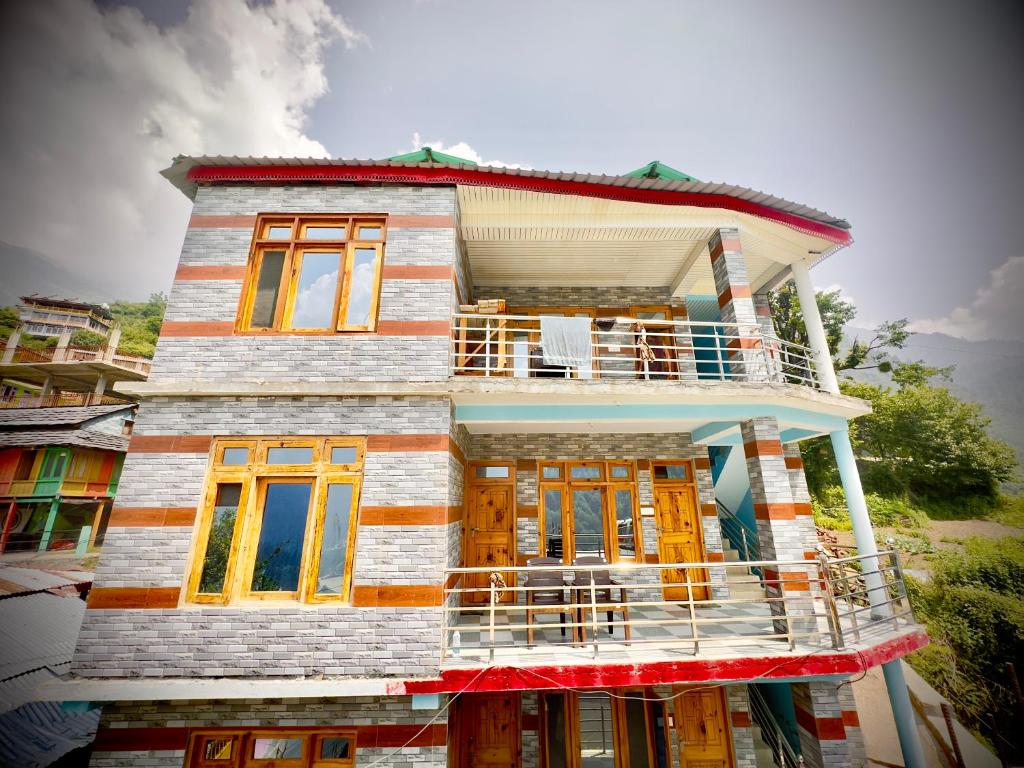 a wooden house with yellow doors and windows at Shivaay guest house in Tosh