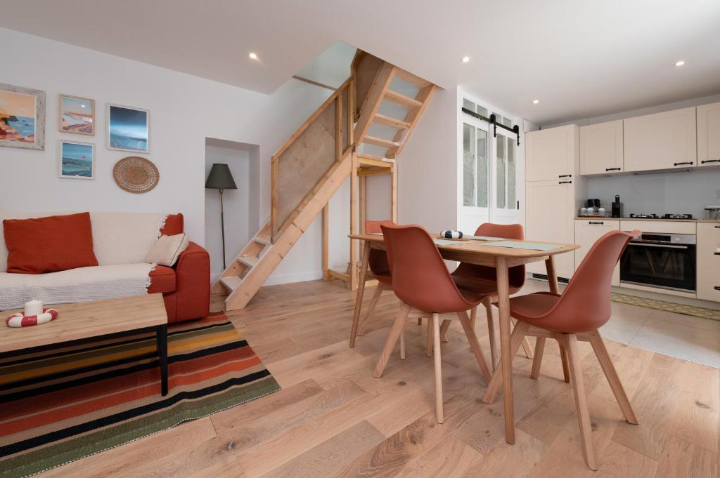 - un salon avec un lit en mezzanine, une table et des chaises dans l'établissement Ker Mam - Belle-Ile, à Sauzon