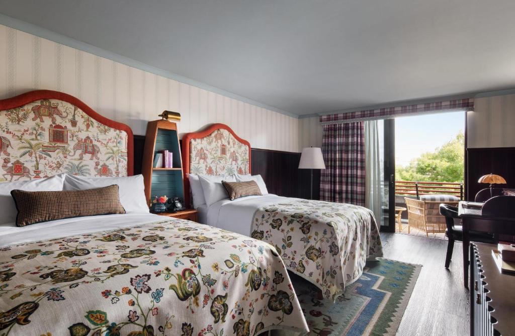 a hotel room with two beds and a balcony at Graduate by Hilton Cambridge in Cambridge