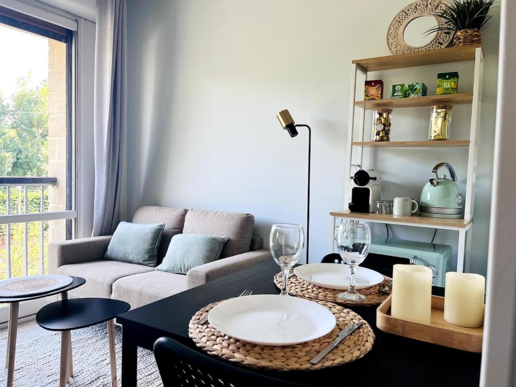 - un salon avec un canapé et une table avec des verres à vin dans l'établissement Studio cosy 80 m de la plage, à Cabourg