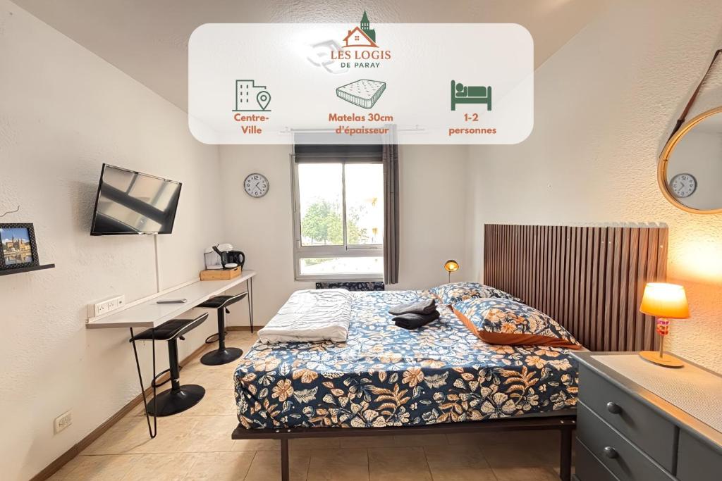 a bedroom with a bed and a desk in it at Les Logis de Paray Appartement 201 in Paray-le-Monial