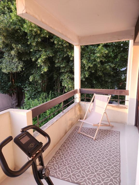 une chaise assise sur le balcon d'une maison dans l'établissement Fully-equipped large studio with terrace, à Rueil-Malmaison