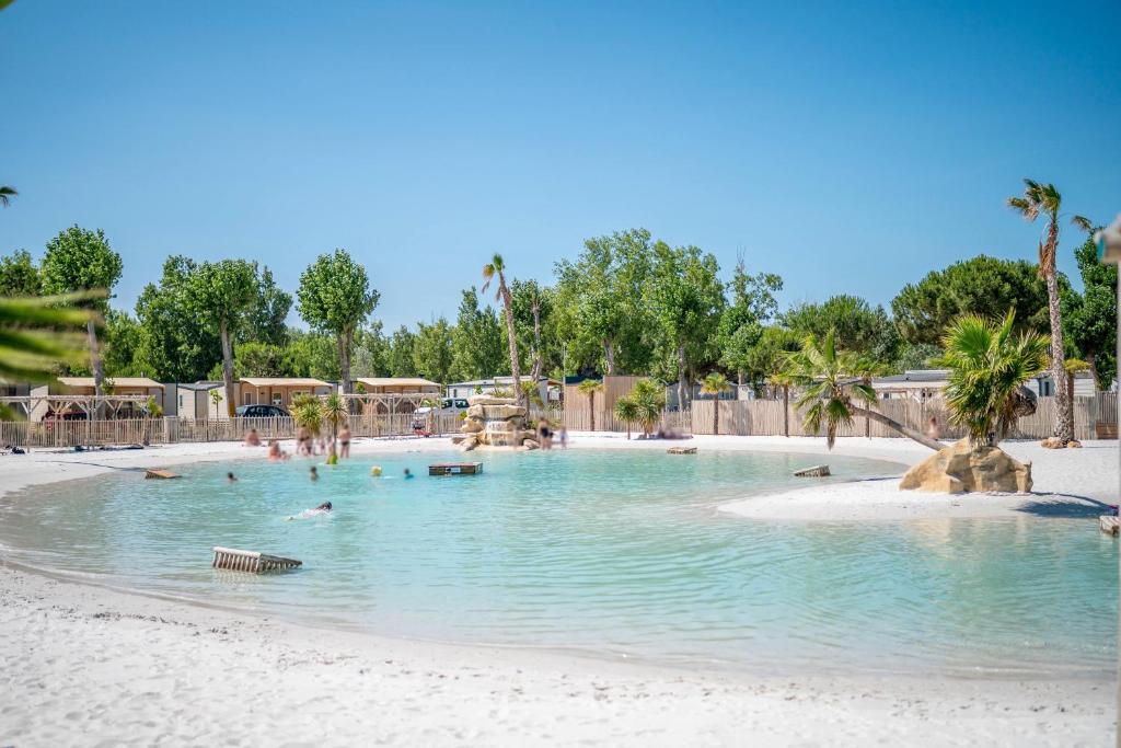 une piscine dans un complexe hôtelier avec des gens qui y nagent dans l'établissement Camping 5 étoiles Location 6 Pers, à Vendres