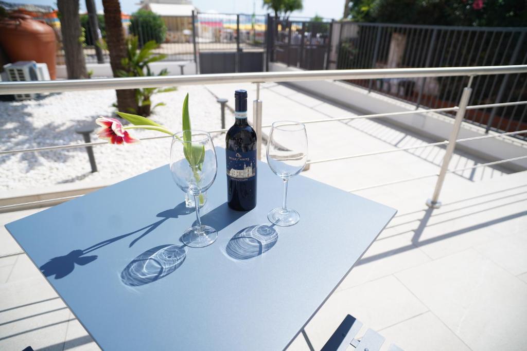 a table with two glasses and a bottle of wine at Regina Elena Luxury Apartments in Mondello