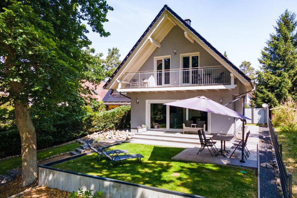 a house with a yard with a patio at Ferienhaus SeeZauber am Fleesensee in Silz