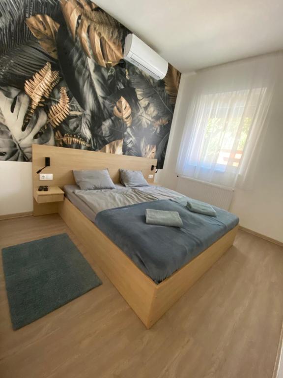 a bedroom with a bed with a mural on the wall at GreBen Apartmanok in Eger