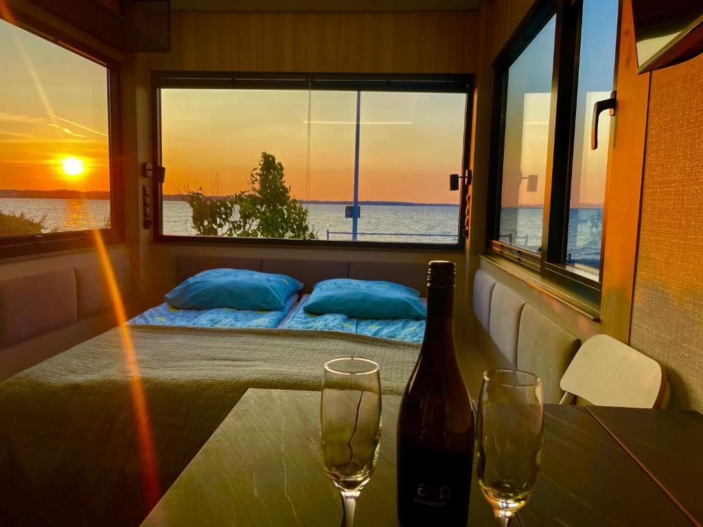 a room with a bed and a table with two wine glasses at Good Spot Rewa in Rewa