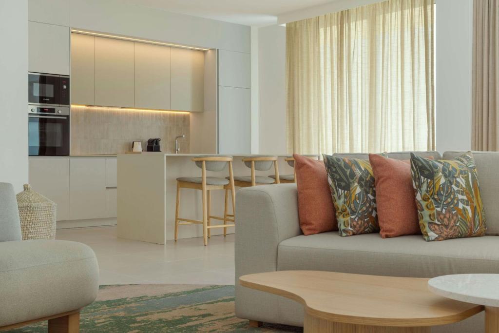 a living room with a couch and a kitchen at The Westin Salgados Beach Resort, Algarve in Albufeira