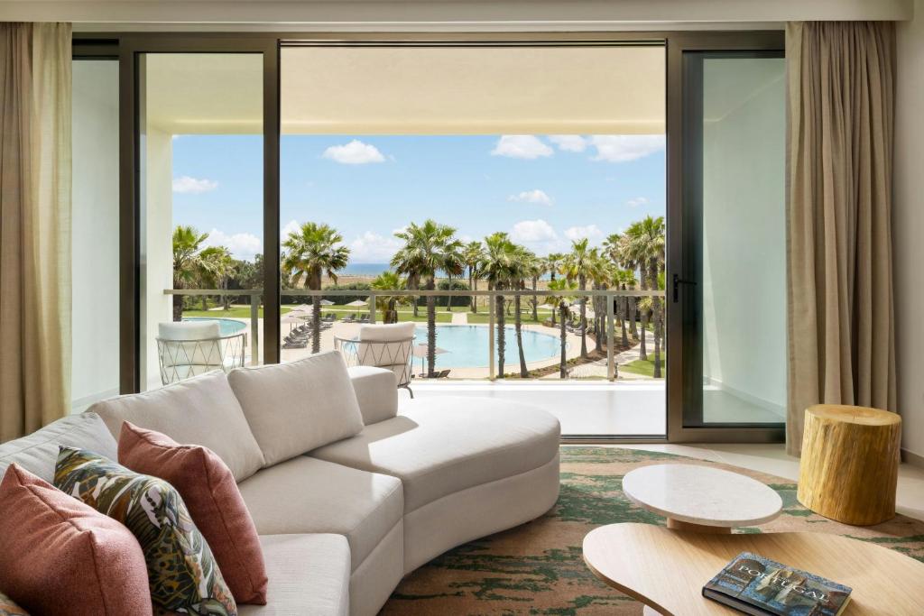 a living room with a couch and a view of the ocean at The Westin Salgados Beach Resort, Algarve in Albufeira