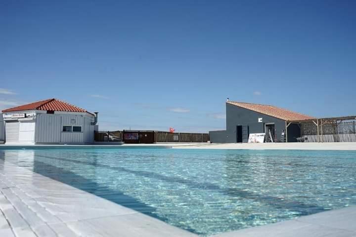 une piscine devant un immeuble dans l'établissement Le Barcarès - Belle vue sur lac - Piscine chauffée, au Barcarès