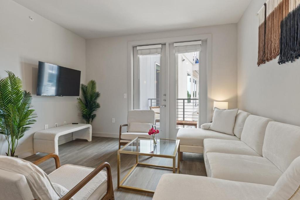 ein Wohnzimmer mit weißen Möbeln und einem Flachbild-TV in der Unterkunft Luxury 2-BR with Juliet Balcony in Austin