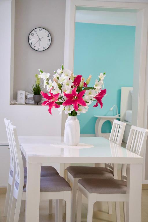a white dining room table with a vase of flowers at Ferienwohnung Sonnenschein in Jüterbog