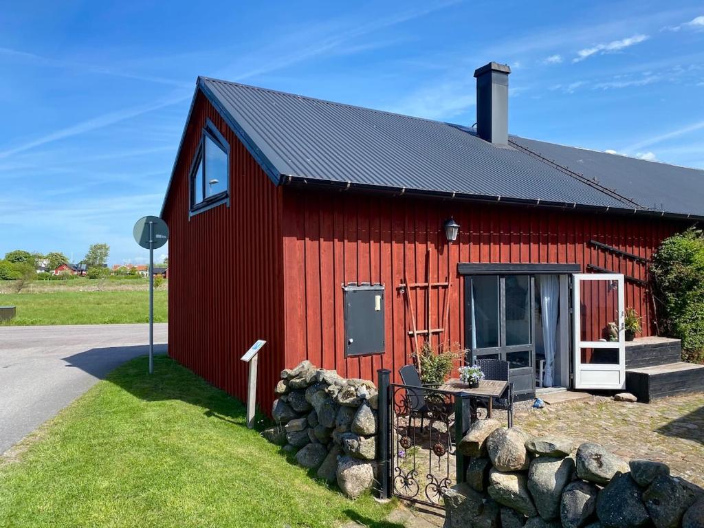 a red barn with a table in front of it at Charming 5 bed studio at Getterön in Varberg