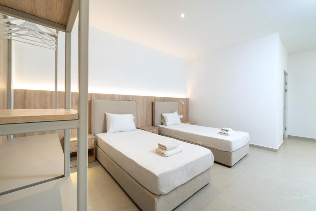 a room with two beds and a couch in it at Boutique Villa Giannis in Limenaria