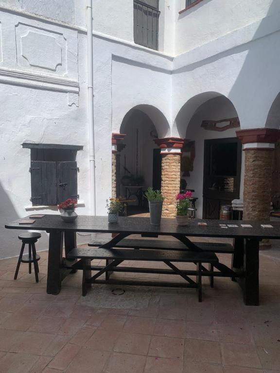 a large wooden picnic table in a courtyard at Casa Rural El Antiguo Juzgado in Jimena de la Frontera