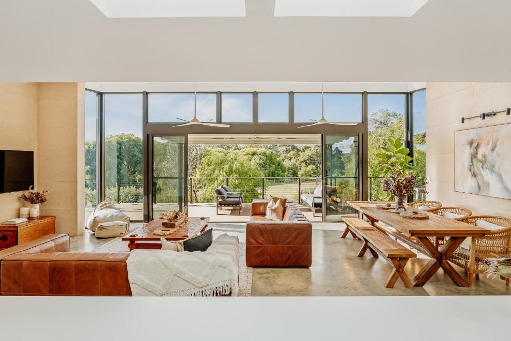 a living room filled with furniture and a large window at Wildwood Retreat a Luxury Vineyard Escape in Yallingup Siding