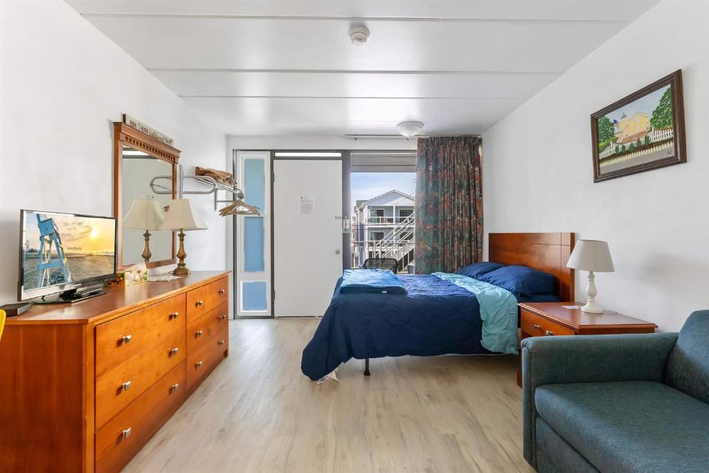 a bedroom with a bed and a couch at 313 E Glenwood Ave, Unit 109 in Wildwood