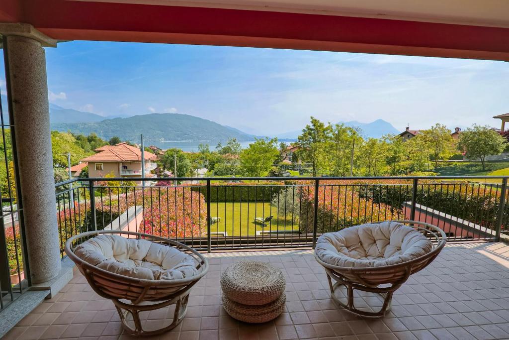 a balcony with two chairs and a view of the mountains at Villetta dei Pascoli in Baveno