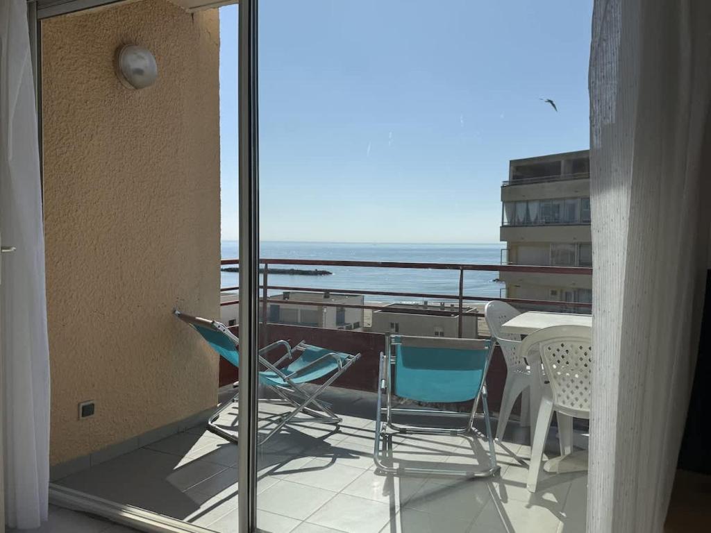 d'un balcon avec des chaises et une table offrant une vue sur l'océan. dans l'établissement Belle appartement vue mer, à Valras-Plage