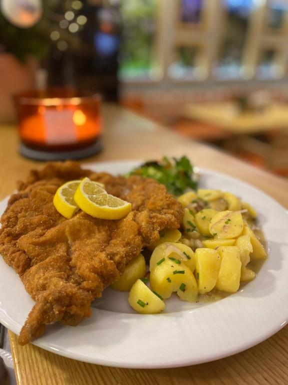 a plate of food with chicken and potatoes on a table at Vetrnik Depandance Hotelu Jirinka in Dolní Morava
