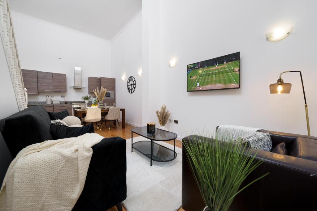 a living room with couches and a tv on the wall at Modern 3BR - Flat Sleeps 8 - Walk to Liverpool St in London
