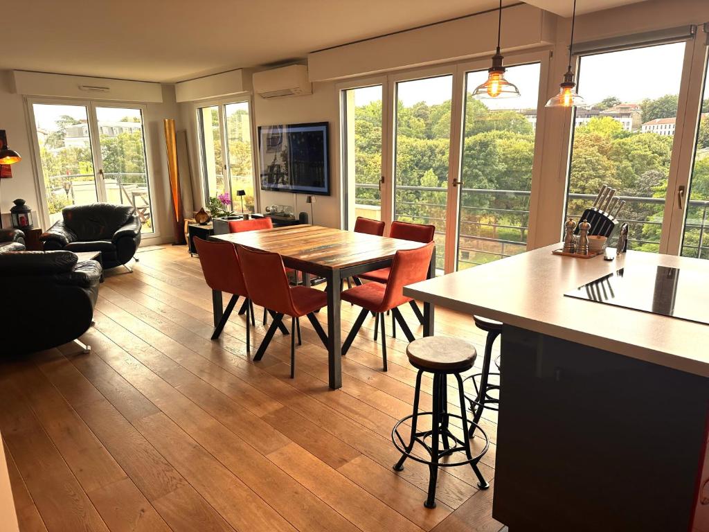 Il dispose d'une cuisine et d'un salon avec une table et des chaises en bois. dans l'établissement Issy - les jardins du séminaire, à Issy-les-Moulineaux