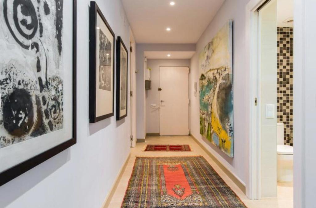 a hallway with paintings on the walls and a rug at Provenza Flat in Barcelona