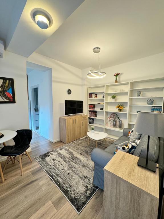 a living room with a blue couch and a table at Hot Spot - Apartment - Sanador Victoriei in Bucharest